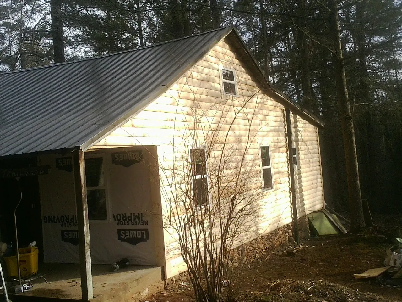 Log siding gable end under a dark metal roof edge in Dayton